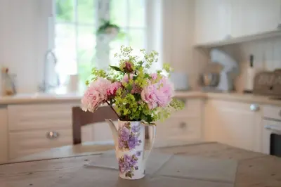 a vase filled with pink and white flowers on a table at Vakker leilighet - stor parkeringsplass 10min fra Bergen in Bergen