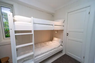 a room with two bunk beds and a door at Vakker leilighet - stor parkeringsplass 10min fra Bergen in Bergen
