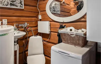 a bathroom with a toilet and a sink and a mirror at Nice Home In Svingvoll in Svingvoll