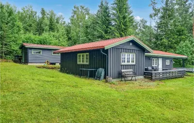 a small shed with a picnic table in a yard at Nice Home In Sagstua With Lake View in Linstad