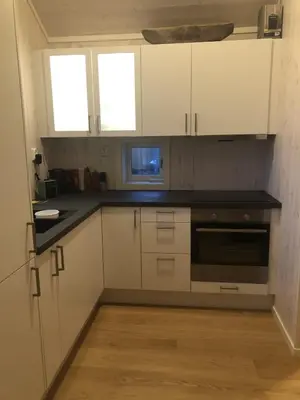 a kitchen with white cabinets and a black counter top at Sykkelhytte ved Slåtten i Synnfjellet in Nord Torpa