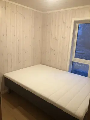 a bed in a room with a window at Sykkelhytte ved Slåtten i Synnfjellet in Nord Torpa