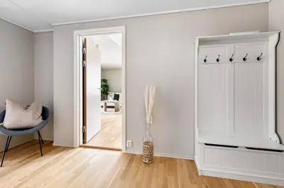 a hallway with a mirror and a blue chair in a room at Beautiful apartment with 3 bedrooms in Sogndal