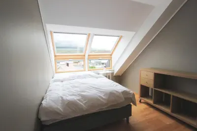 a small bedroom with a bed and a window at Beautiful apartment with 3 bedrooms in Sogndal