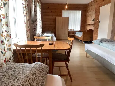 a room with a table and chairs and a bedroom at Fjordshelter dorm in Tysso