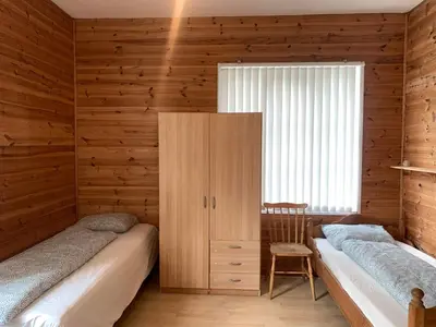 two beds in a room with wooden walls at Fjordshelter dorm in Tysso