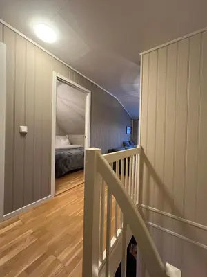 a bedroom with a bed and a stairway with a doorway at Røstad Apartment - with Kitchen and Free Parking in Trondheim