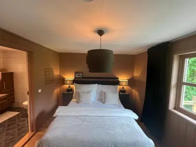 a bedroom with a large white bed with a chandelier at Røstad Apartment - with Kitchen and Free Parking in Trondheim
