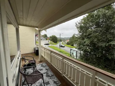 a balcony with two chairs and a view of a street at Røstad Apartment - with Kitchen and Free Parking in Trondheim