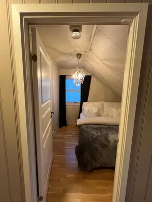 a bedroom with a bed and a chandelier at Røstad Apartment - with Kitchen and Free Parking in Trondheim