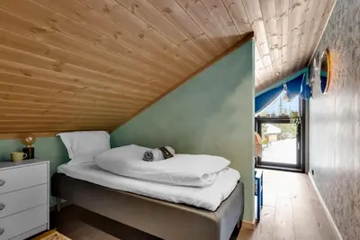 a bed in a small room with a wooden ceiling at Private Room in Beautiful Mountain Home w/ Sauna in Beitostøl