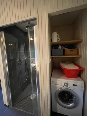 a washing machine in a bathroom with a shower at Baybu - cabin close Geilo Skisenter and the center of Geilo in Geilo