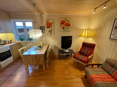 a living room with a table and a couch and a television at Kjerkgata 6 - midt i Røros sentrum in Røros