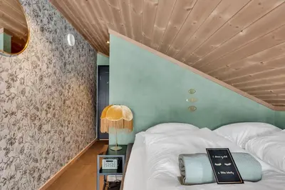 a bedroom with a bed with a wooden ceiling at Peaceful Oasis. Panoramic forest- & mountain view. Sauna. in Beitostøl