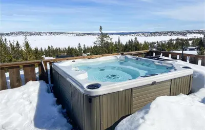 a hot tub on a deck in the snow at 5 Bedroom Gorgeous Home In Sjusjøen in Sjusjøen