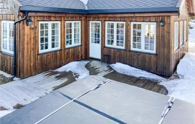 a wooden house with snow on the ground at 5 Bedroom Gorgeous Home In Sjusjøen in Sjusjøen