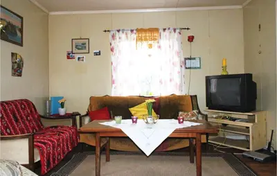 a living room with a table and a tv at Amazing Home In Dale I Sunnfjord in Gjølanger