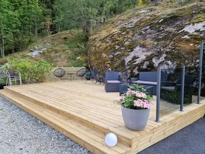 a wooden deck with chairs and a table at Kvamsdal Pensjonat 1 in Eidfjord