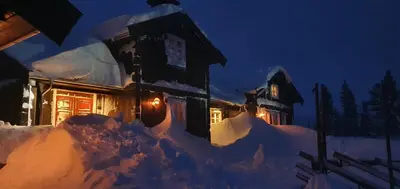 a house covered in snow at night at Luxurious, well-Equipped and modern Cabin by the Cross-Country Ski Trails in Eggedal