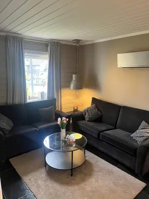 a living room with two couches and a coffee table at Cosy and well-equipped apartment with free parking in Trondheim