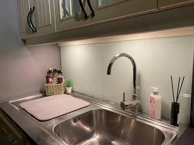 a kitchen sink with a towel and a faucet at Cosy and well-equipped apartment with free parking in Trondheim