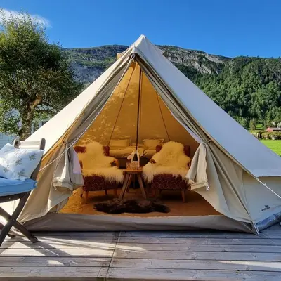 a tent with two chairs and a table in it at Flatheim Glamping in Viksdalen