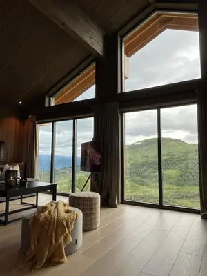 a living room with large windows and a couch at Sogndal Chalet in Sogndal