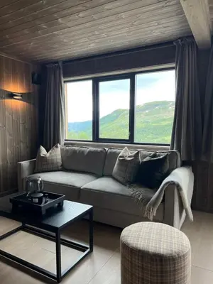 a living room with a couch and a table at Sogndal Chalet in Sogndal