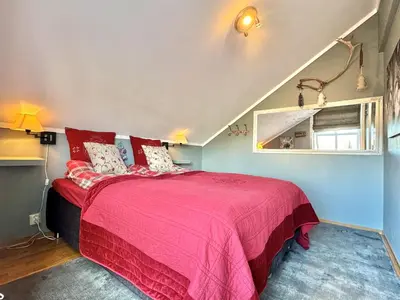 a bedroom with a bed with a pink bedspread at Spacious and beautiful apartment in Geilo, mountain retreat with view! in Geilo