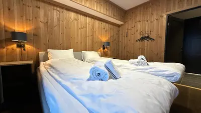 a bedroom with two beds with white sheets at Leiligheter på Fyri Resort - Hemsedal in Hemsedal