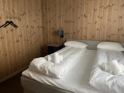 two beds in a room with white sheets and pillows at Leiligheter på Fyri Resort - Hemsedal in Hemsedal