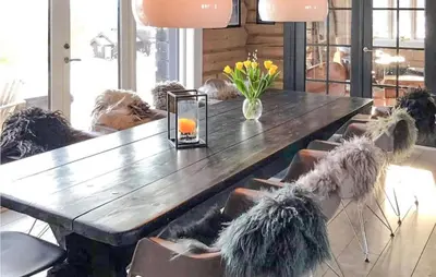 a wooden table with chairs and a vase of flowers on it at 5 Bedroom Gorgeous Home In Tynset in Tynset
