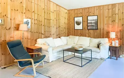 a living room with a couch and a table and a chair at 2 Bedroom Stunning Home In Dovre in Dovre