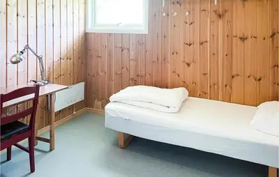 a room with a bed and a desk and a lamp at 2 Bedroom Stunning Home In Dovre in Dovre