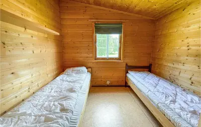 a room with two beds in a log cabin at Gorgeous Home In Dovre With Wifi in Dovre