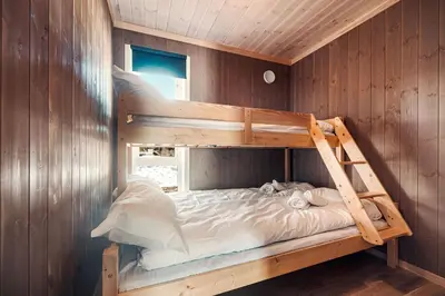 a bedroom with two bunk beds in a wooden wall at Harevadet 211 in Hornindal