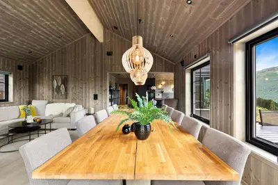 a dining room with a wooden table and chairs at Hodlekvevegen 307 in Sogndal