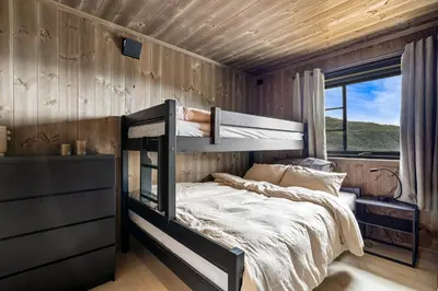 a bedroom with a bunk bed in a wooden wall at Hodlekvevegen 307 in Sogndal