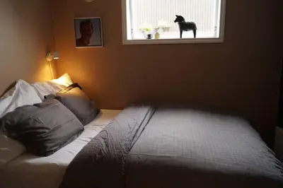 a bedroom with a bed with a dog statue in the window at Koselig leilighet i Langevåg in Holen