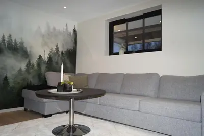 a living room with a couch and a table at Koselig leilighet i Langevåg in Holen