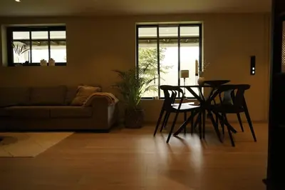 a living room with a table and chairs and a couch at Koselig leilighet i Langevåg in Holen