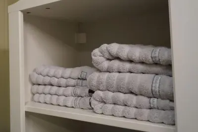 a bunch of towels are stacked on a shelf at Koselig leilighet i Langevåg in Holen