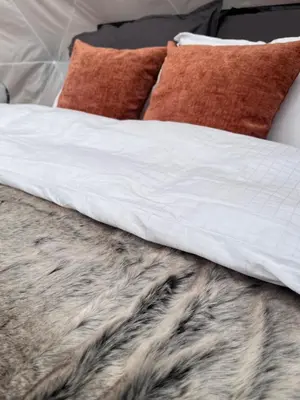 a bed with a white comforter and pillows on it at Arctic Dome Gudbrandsdalen in Sør-Fron
