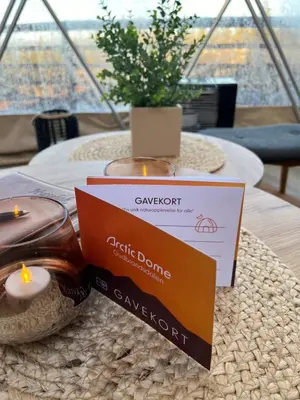 a table with a candle and a sign on it at Arctic Dome Gudbrandsdalen in Sør-Fron