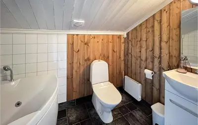 a bathroom with a toilet and a tub and a sink at 4 Bedroom Beautiful Home In Nord-Torpa in Nord Torpa