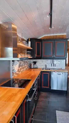 a kitchen with black cabinets and a wooden counter top at Skurdalsvegen 37L in Geilo