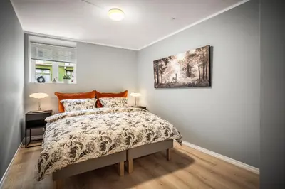 a bedroom with a bed and a painting on the wall at Corner Apartments in Bergen