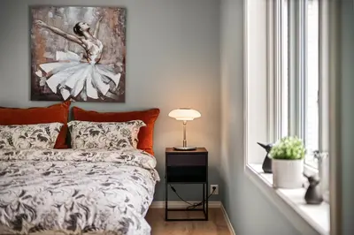 a bedroom with a bed and a painting on the wall at Corner Apartments in Bergen