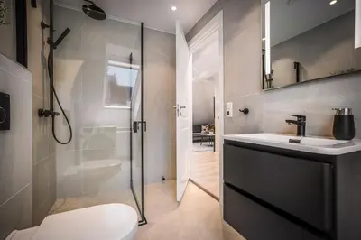 a bathroom with a shower and a toilet and a sink at Corner Apartments in Bergen