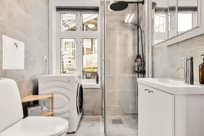 a bathroom with a toilet a sink and a shower at Dinbnb Apartments I Views & Street Parking in Sandviken in Bergen